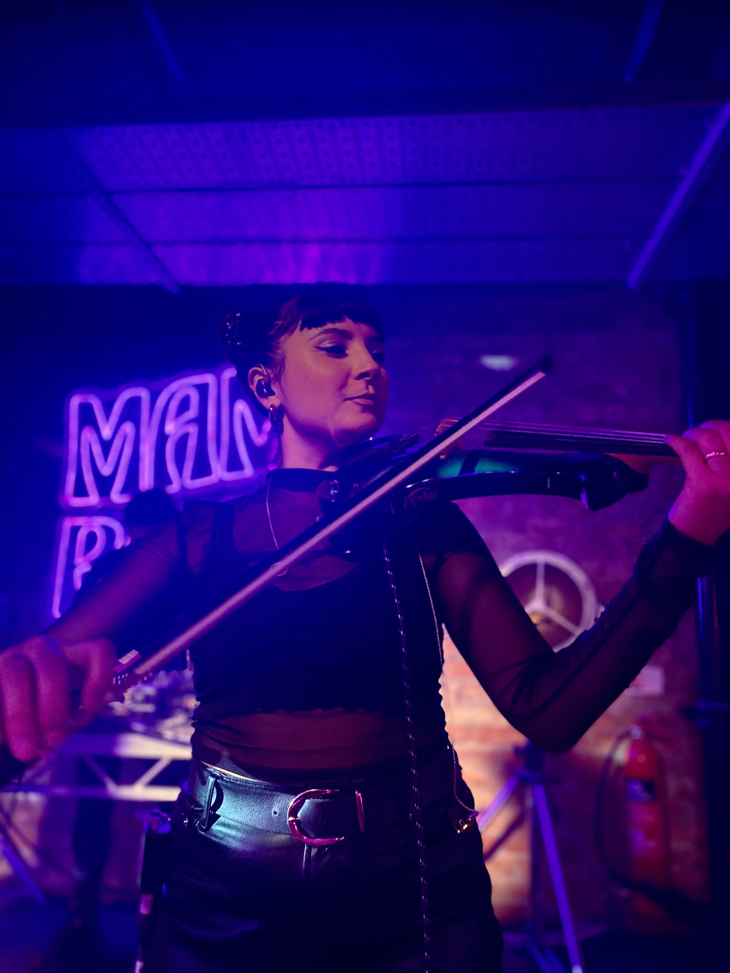 Sophia playing the electric violin at a nightclub